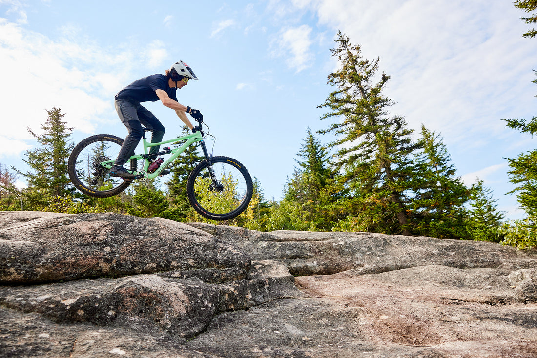 woman riding a bike on a road with a mountain in the background