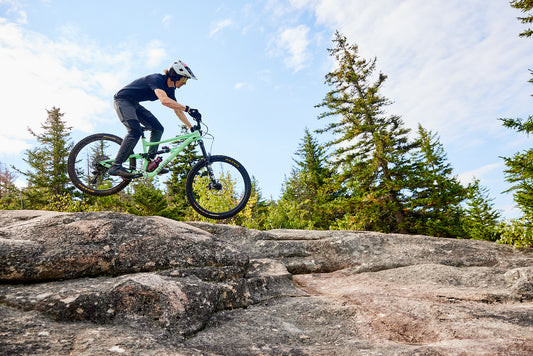 woman riding a bike on a road with a mountain in the background