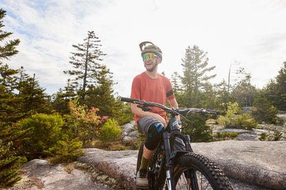 man sitting on mountain bike wearing uvex sportstyle 236 sunglasses