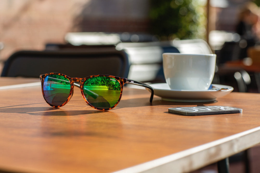 uvex lgl 43 sunglasses on an outdoor cafe table