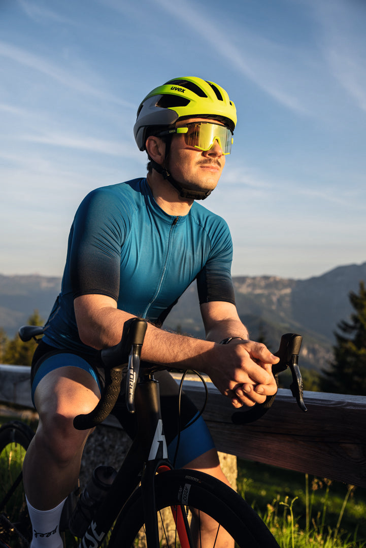 man leaning on bike handlebars wearing uvex sportstyle 236 sunglasses