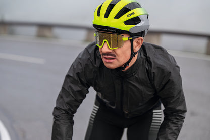man riding bike in the rain wearing uvex sportstyle 236 sunglasses